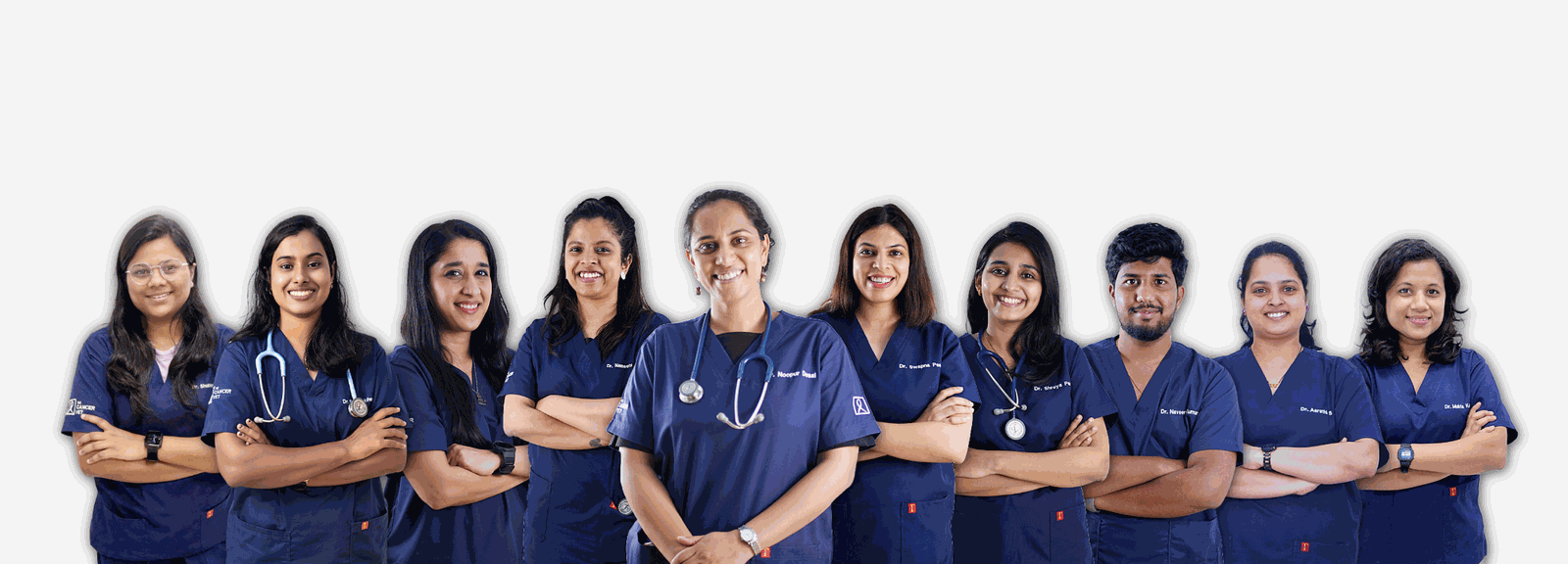 A studio line-up of the clinical team in navy embroidered scrubs