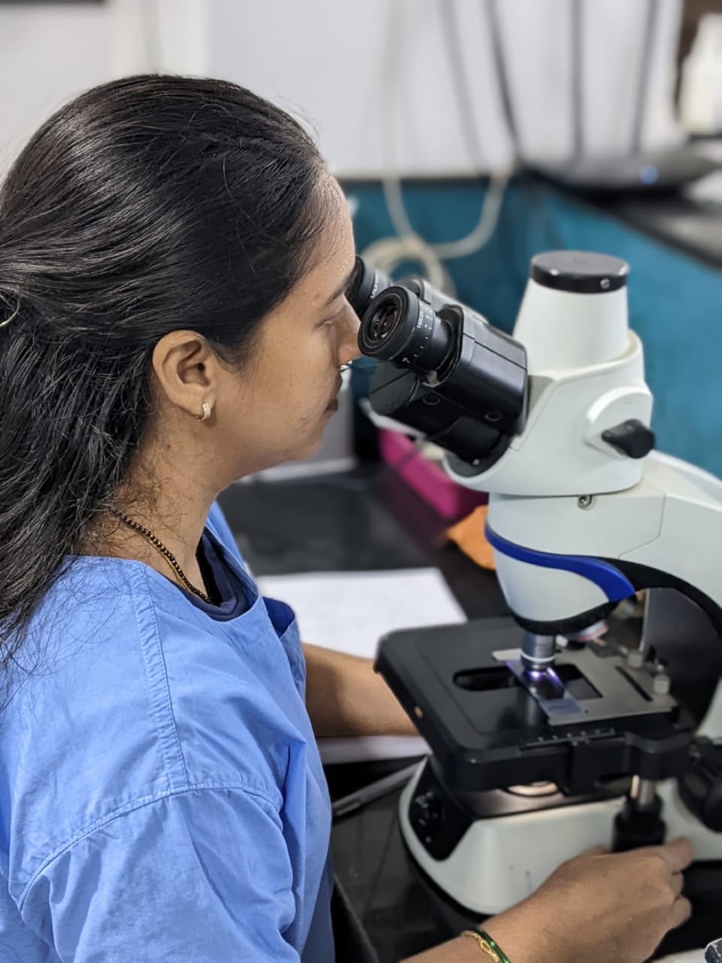 A clinician at a binocular microscope in the in-house laboratory